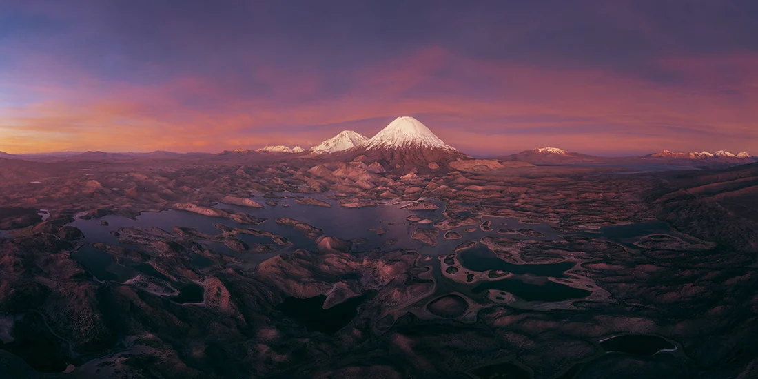 Epson International Pano Awards 2026 Kazananları Açıklandı 15 Epson International Pano Awards 2026
Gün batımında karla kaplı volkanik bir dağ, koyu renkli ve birbirine bağlı göllerle çevrili geniş ve engebeli bir manzaranın üzerinde yükseliyor.