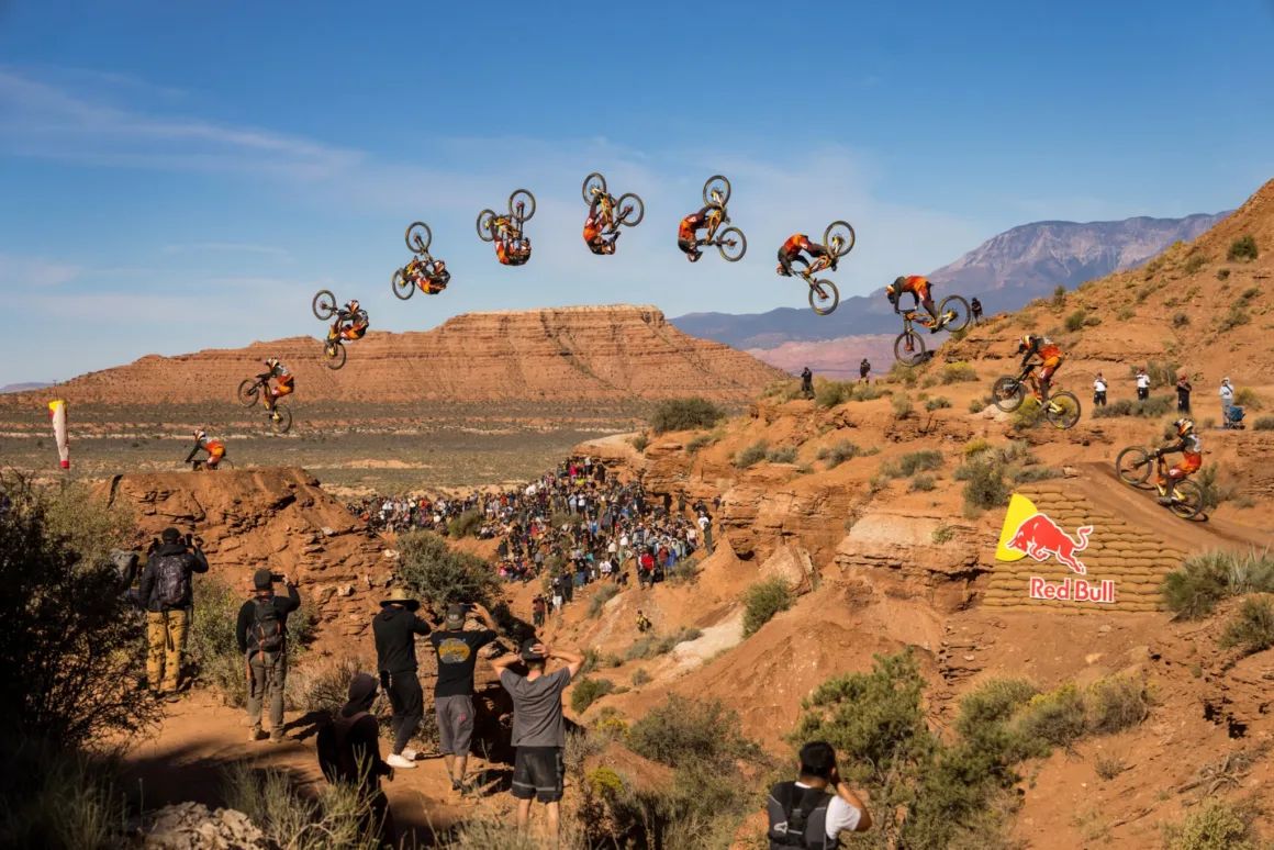 Uçurumun Kenarında Fotoğraf: Red Bull Rampage’in Görünmeyen Yüzü 27 Kompozit aksiyon fotoğrafında bir dağ bisikletçisi çöl kanyonunun üzerinde ters takla yaparken aşağıdaki kalabalık onu izliyor.