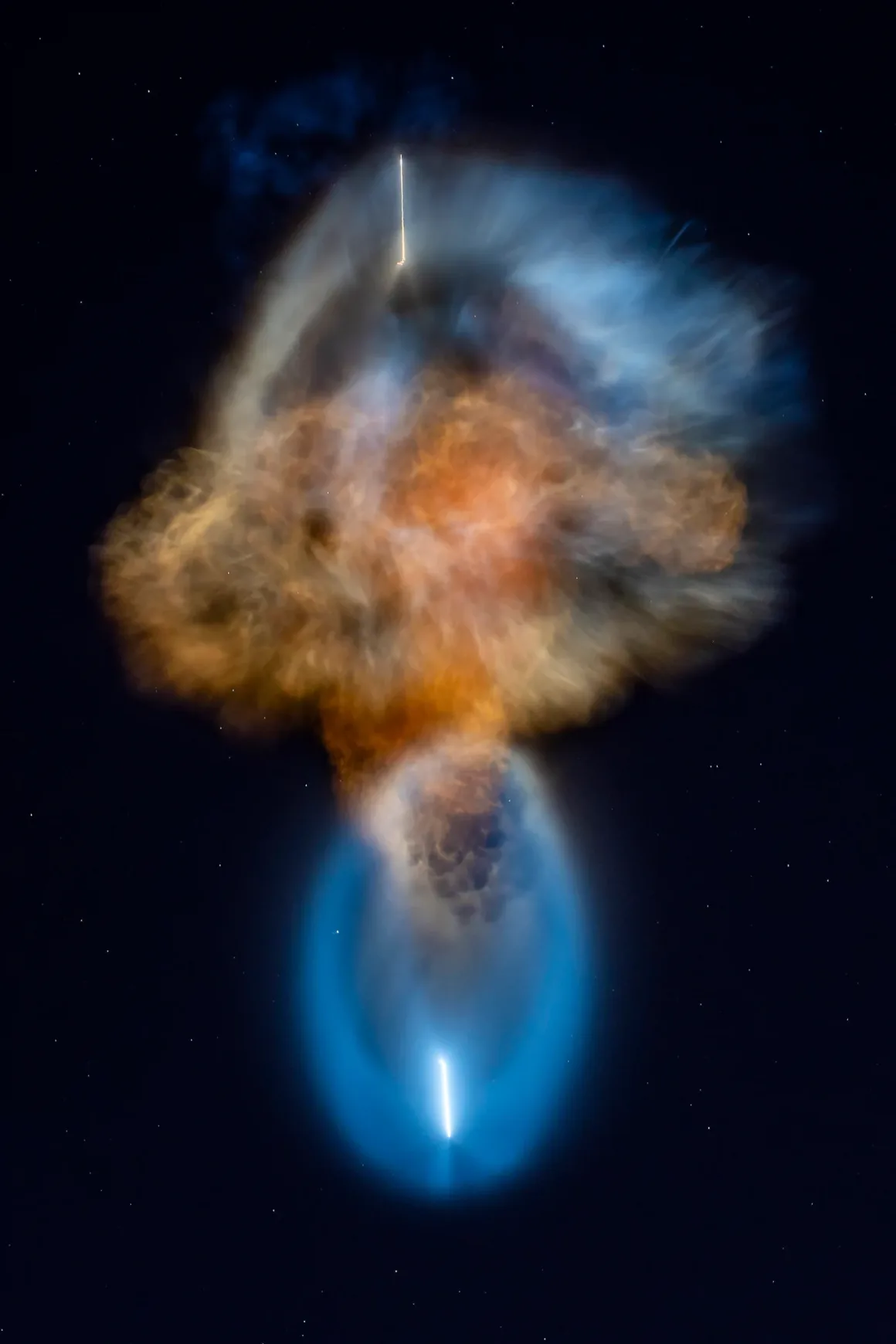 NASA’nın “Uzay Denizanası” Fotoğrafları Gökyüzünü Aydınlattı 21 Parlak bir roket egzoz bulutu, karanlık ve yıldızlı gece gökyüzünde büyük, mavi ve turuncu tonlarda nebula benzeri bir şekil oluşturuyor.