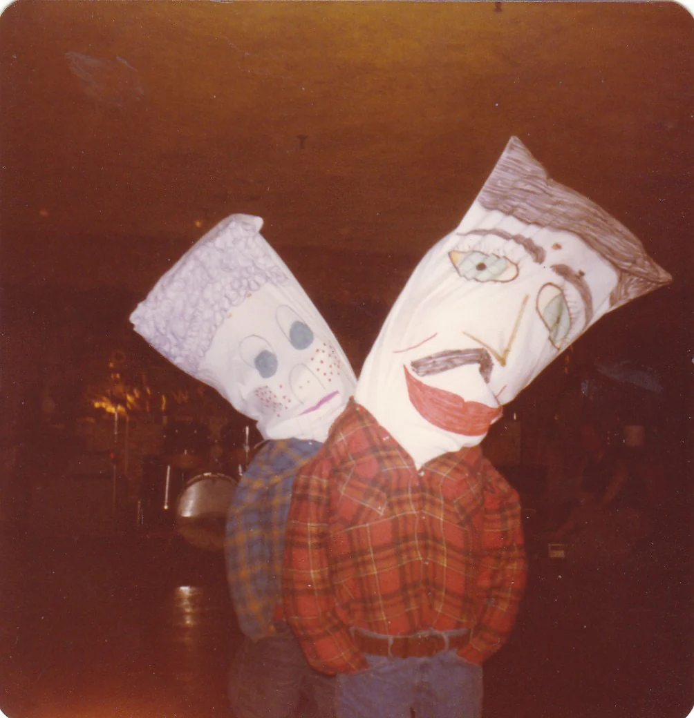 20. Yüzyıl Ortalarından Tekinsiz Halloween Fotoğrafları 18 20. Yüzyıl Ortalarından Tekinsiz Halloween Fotoğrafları
Başlarında elle çizilmiş büyük kâğıt torba maskeleri bulunan ve ekose gömlek giyen iki kişi yan yana duruyor