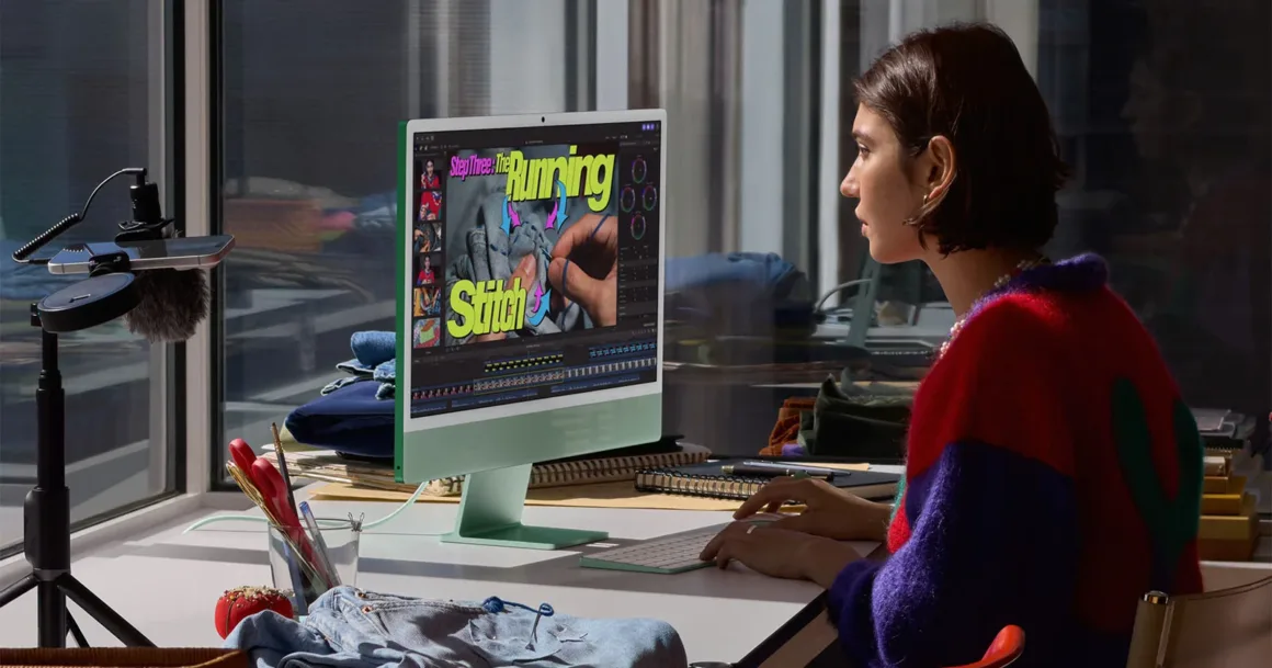 M6 iMac Tanıtıldı: Daha Güçlü Performans, Wi-Fi 7 ve 7 Renk Seçeneği 19 Bir kişi masada yeşil renkli iMac üzerinde dikişle ilgili bir video düzenliyor; sol tarafta tripod üzerinde bir kamera bulunuyor.