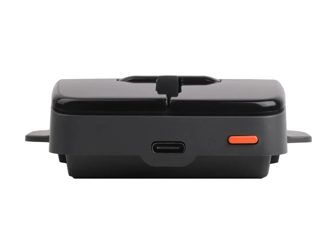 Super Mouse Tanıtıldı: Dokunmatik Ekranlı Fare Üretkenlik Merkezi Olmayı Hedefliyor 22 A black, rectangular electronic device with a USB-C port and a small orange button on its front face, viewed from a low angle.