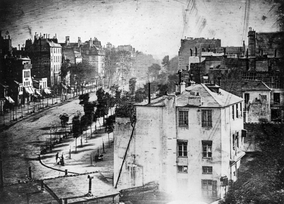 Fotoğraftaki İlk İnsanların Durduğu Yer 188 Yıl Sonra Bulundu
Siyah-beyaz dagerreyotipte, ağaçlar ve çok katlı binalarla çevrili sakin ve boş bir Paris caddesi görülüyor; kaldırımda tek bir insan figürü duruyor.