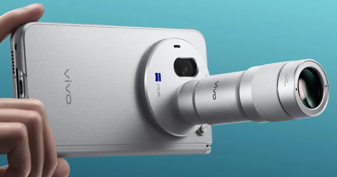 Vivo X Fold6: Katlanabilir Telefonda 200 MP Zeiss Kamera Sistemi 23 Bir el, arkasında büyük dairesel kamera modülü ve belirgin biçimde dışarı uzanan telefoto objektif bulunan gümüş renkli bir akıllı telefonu tutuyor.
