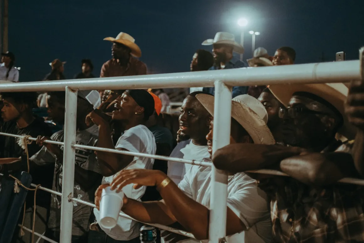 Ivan McClellan, Siyah Kovboy Kültürünü 10 Yıllık Fotoğraf Projesinde Belgeledi 20 Oklahoma'daki rodeo etkinliğinde kalabalık bir izleyici grubu tribün ve arena çevresinde görülüyor.
