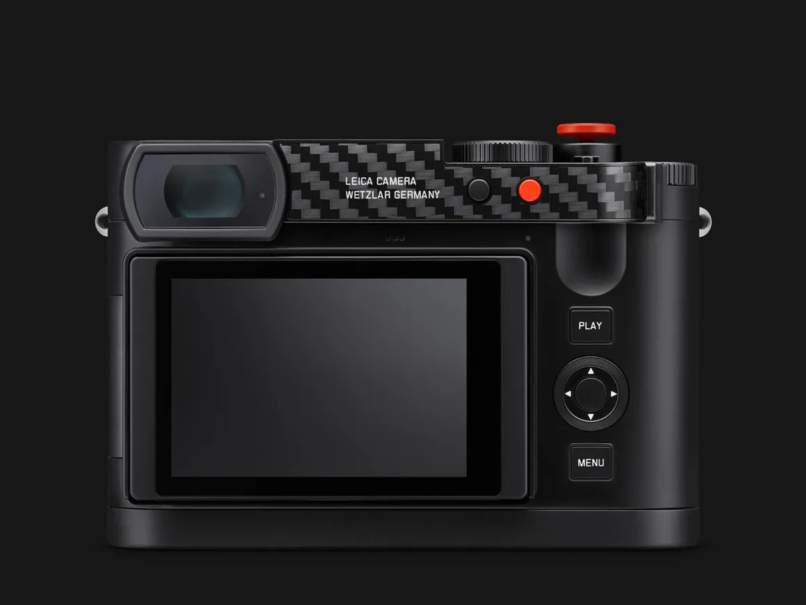 Leica Q3 43 Formula 1 Edition: Karbon Fiber Detaylı Özel Seri 24 Karbon fiber detaylara, büyük LCD ekrana, yön tuşlarına ve PLAY ile MENU düğmelerine sahip siyah dijital fotoğraf makinesinin arka görünümü.
