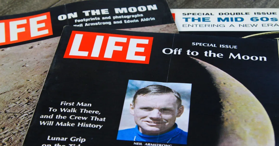 Life Dergisi 90 Yıl Sonra Yeniden Basılı Yayına Dönüyor 1 Ahşap bir yüzey üzerinde Apollo Ay görevleri ve 1960’lara ilişkin başlıklar taşıyan üç eski LIFE dergisi kapağı yan yana duruyor.