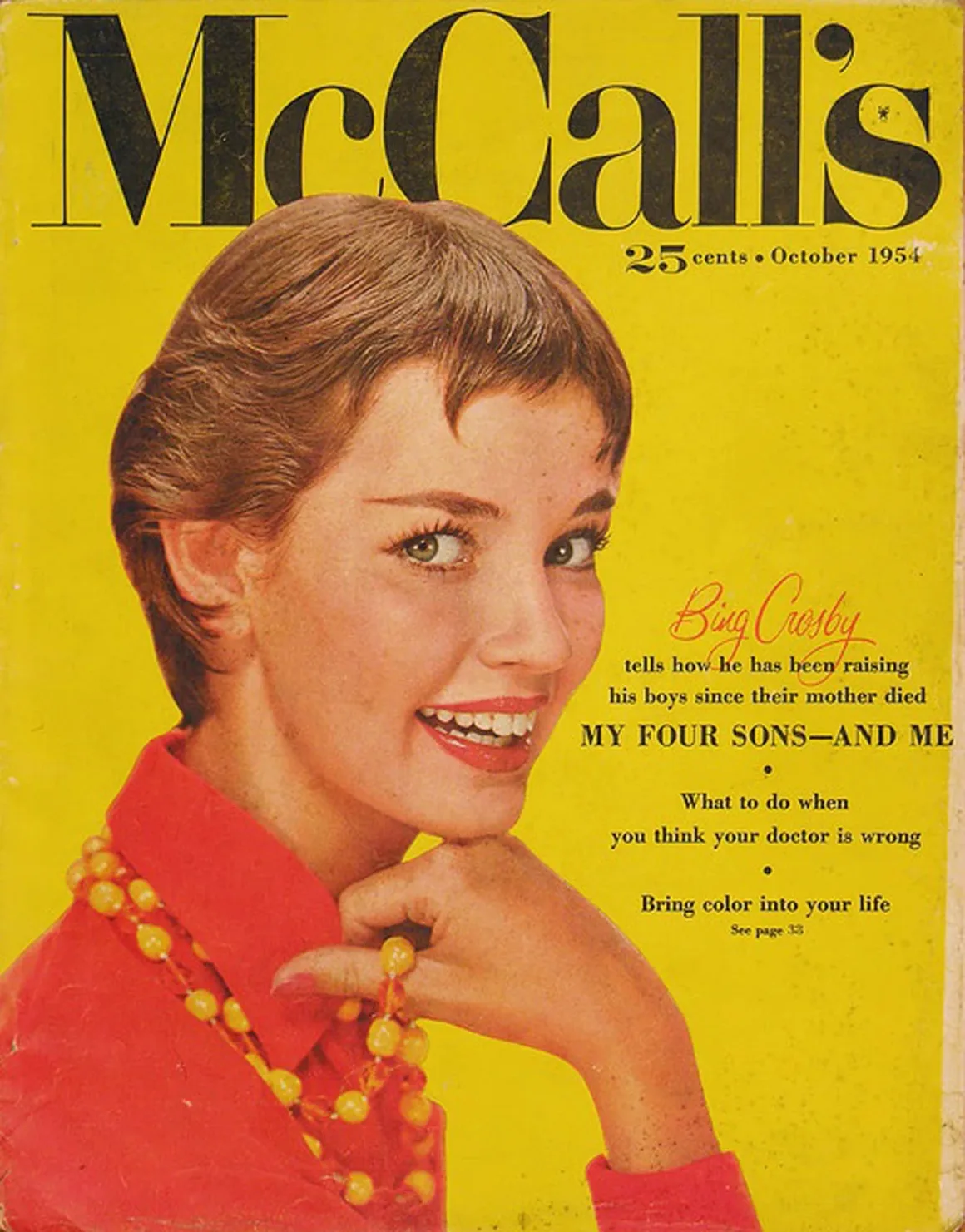 Fotoğraflarda Neden Gülümsüyoruz? Portre Geleneğinin Değişen Yüzü 23 McCall's dergisinin Ekim 1954 kapağında kısa kahverengi saçlı gülümseyen bir kadın, parlak sarı arka plan önünde kırmızı bluz ve sarı boncuklu kolye giyiyor.