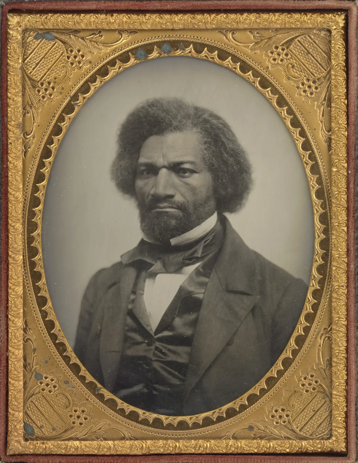 Frederick Douglass’ın baş ve omuzlarını gösteren, süslü oval altın renkli çerçeve içindeki ambrotype portresi.