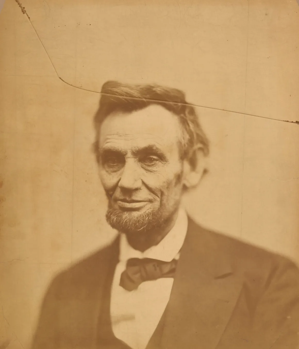 Abraham Lincoln’ün baş ve omuzlarını gösteren sepya tonlu portre; görüntünün üst kısmında belirgin çapraz bir çatlak bulunuyor.