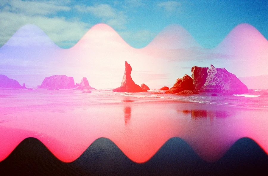 Psychedelic Blues: Analog Fotoğrafçılıkta Renk, Işık ve Rastlantının Peşinde 31 Büyük kaya oluşumlarının bulunduğu kıyı manzarası. Görüntünün üzerinde parlak pembe ve mor renklerde dalgalı ışık sızmaları görülüyor.