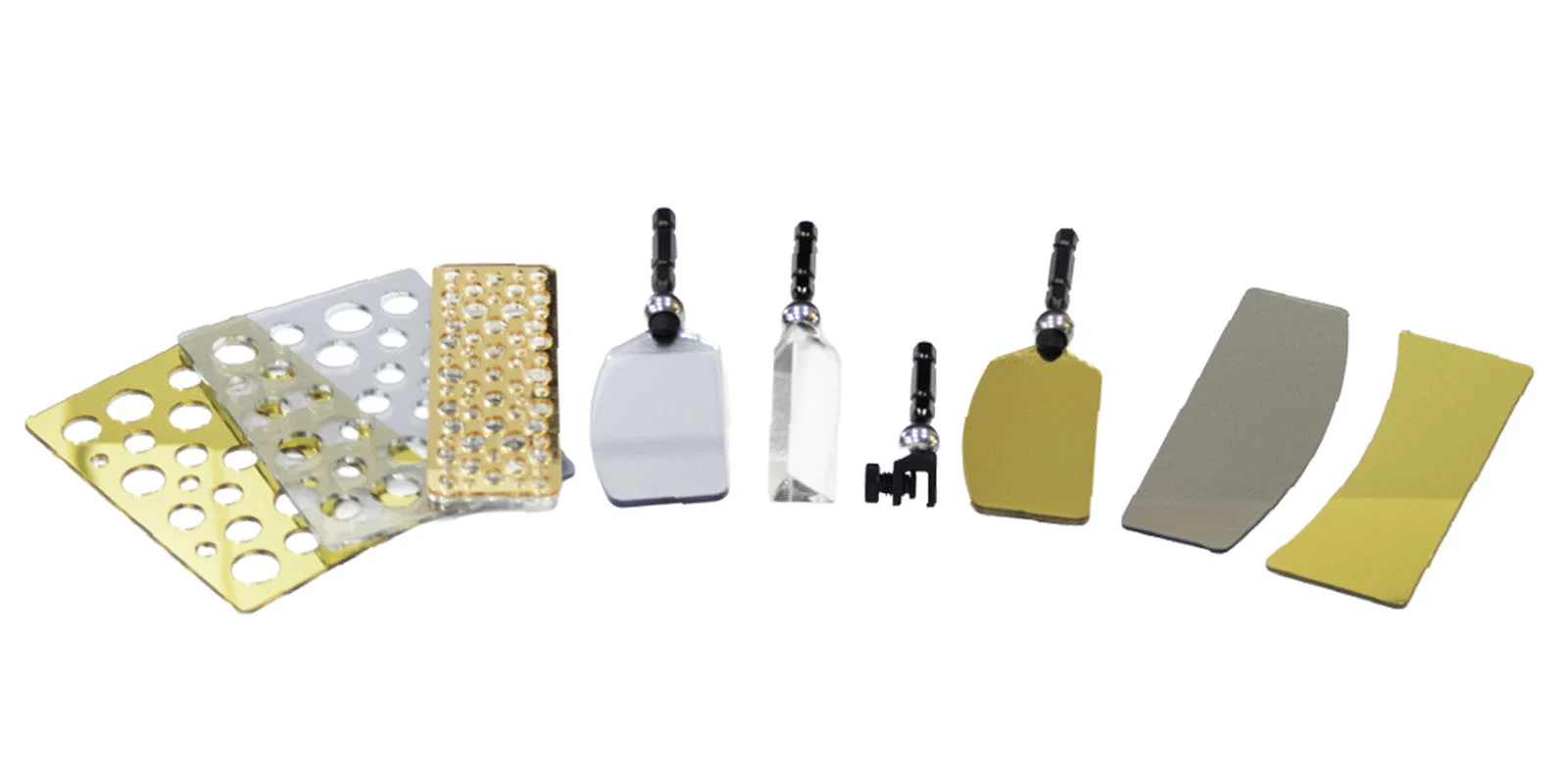 Lensbaby Omni Color II ve Omni Crystal II ile Çekim Sırasında Yaratıcı Efektler 29 A collection of various optical components, including perforated metal sheets, small mirrors, a prism, and mounting hardware, arranged on a white background.