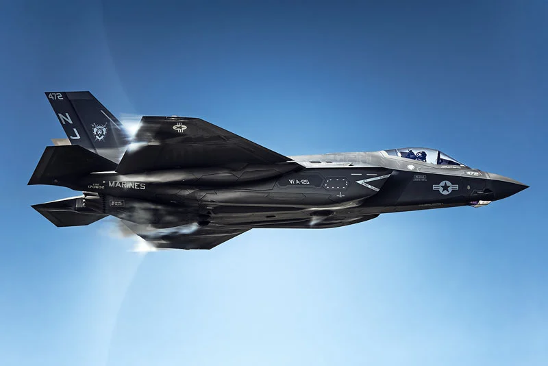 Hızı Fotoğrafa Dönüştürmek: Simone Marulli’nin Uçak Kareleri 22 Üzerinde MARINES ve VFA-125 işaretleri bulunan koyu gri bir F-35 savaş uçağı açık mavi gökyüzünde uçuyor.