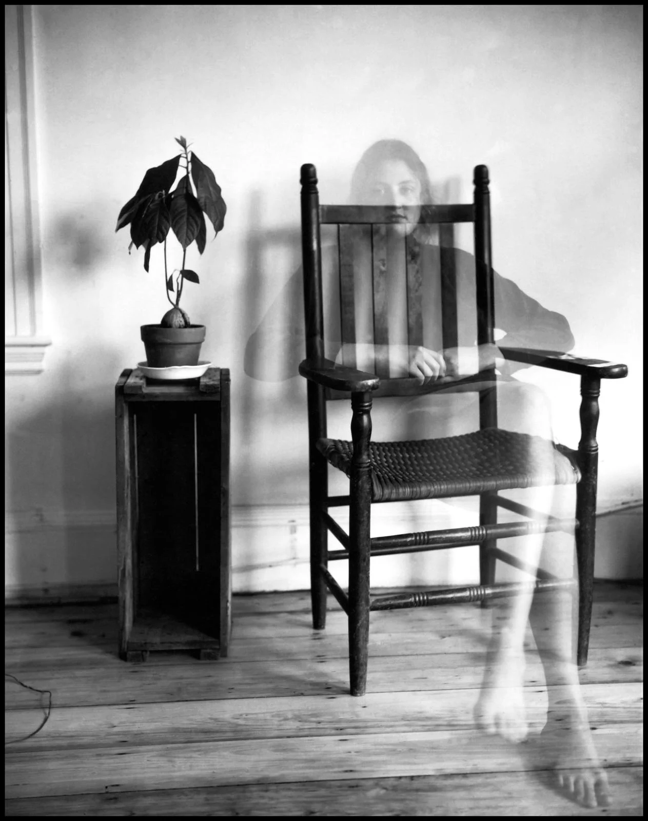 Magnum Fact/Fiction Square Print Sale 26 Ekim’de Başlıyor 20 A double-exposure black and white photograph shows a translucent woman sitting on a wooden chair next to a potted plant.