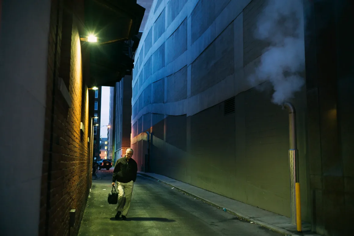 Alex Webb’in Walking Blues’u: Amerika Sokaklarında Renk, Ritim ve Rastlantı 19 Elinde evrak çantası taşıyan yaşlı bir adam, duvardan yükselen buharın yanından geçerek dar ve loş bir şehir geçidinde yürüyor.