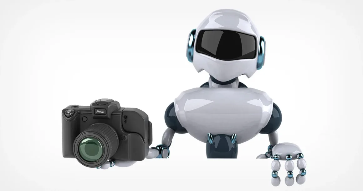 Agentic AI Fotoğrafçılara Yardımcı Olabilir mi?
Beyaz arka plan önünde sağ elinde siyah bir fotoğraf makinesi tutan beyaz ve koyu mavi robot.