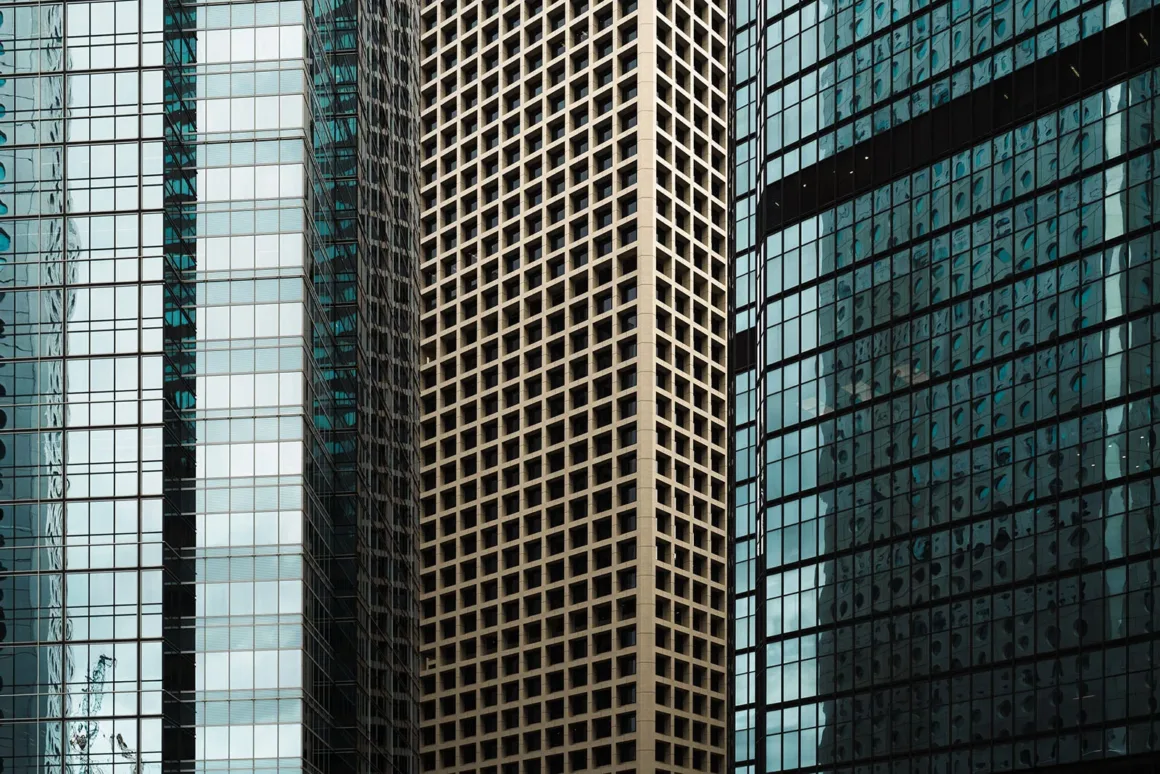 Architecture Photography MasterPrize 2026 Kazananları Açıklandı 22 Birbirine bitişik üç gökdelenin farklı cam ve beton ızgara cepheleri kadrajı tamamen dolduruyor.