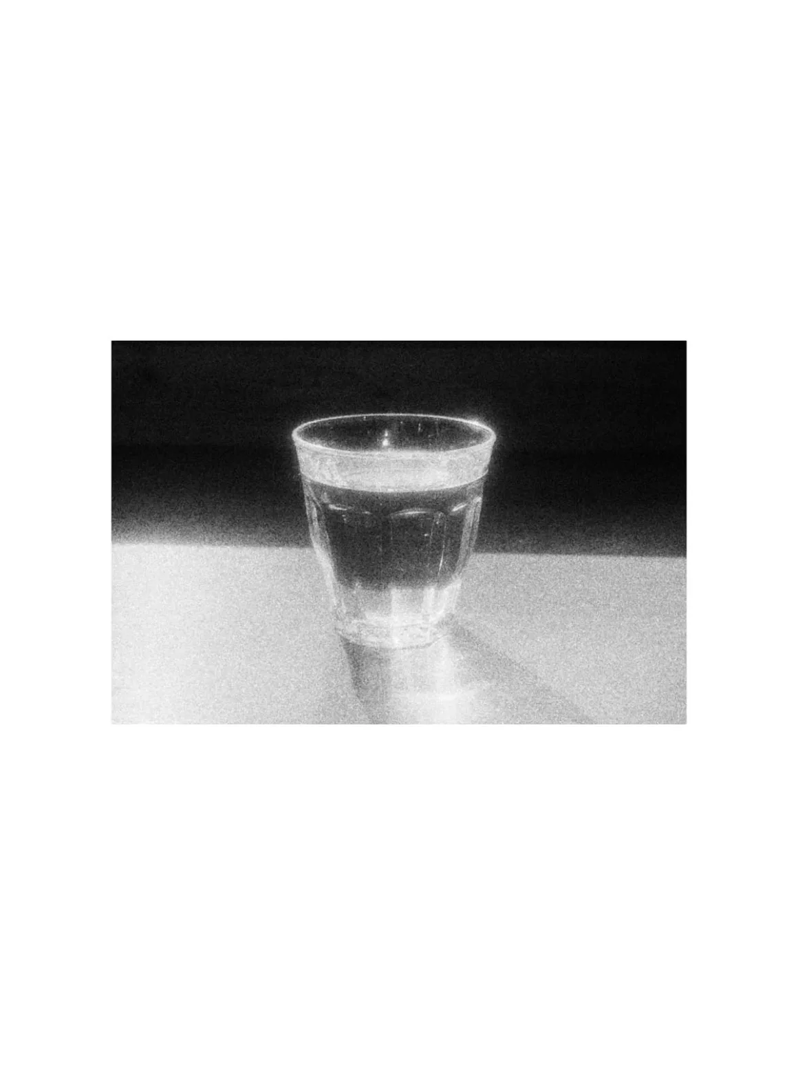 MARS: iPhone’a Analog Film Hissi Getiren Siyah-Beyaz Kamera Uygulaması 24 A clear glass filled with liquid sits on a flat surface against a dark background.