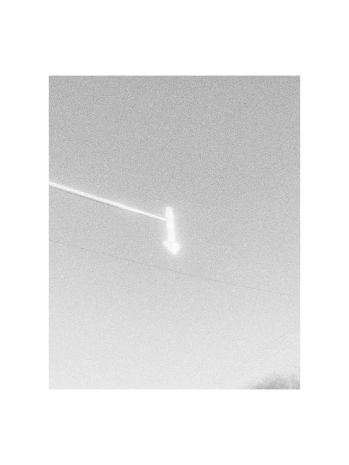MARS: iPhone’a Analog Film Hissi Getiren Siyah-Beyaz Kamera Uygulaması 28 A bright, glowing arrow sign points downward against a pale, overcast sky.