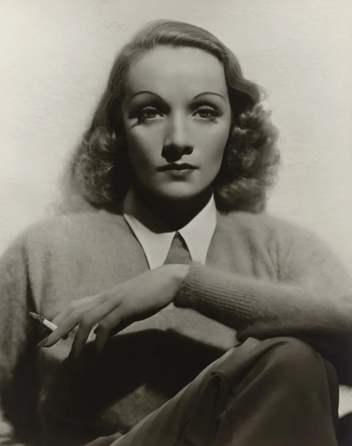 Hollywood’un Altın Çağındaki Glamoru Fotoğraflayan Adam: George Hurrell 22 Marlene Dietrich, yakalı gömlek ve kazak giyiyor; sağ elinde sigara tutuyor.