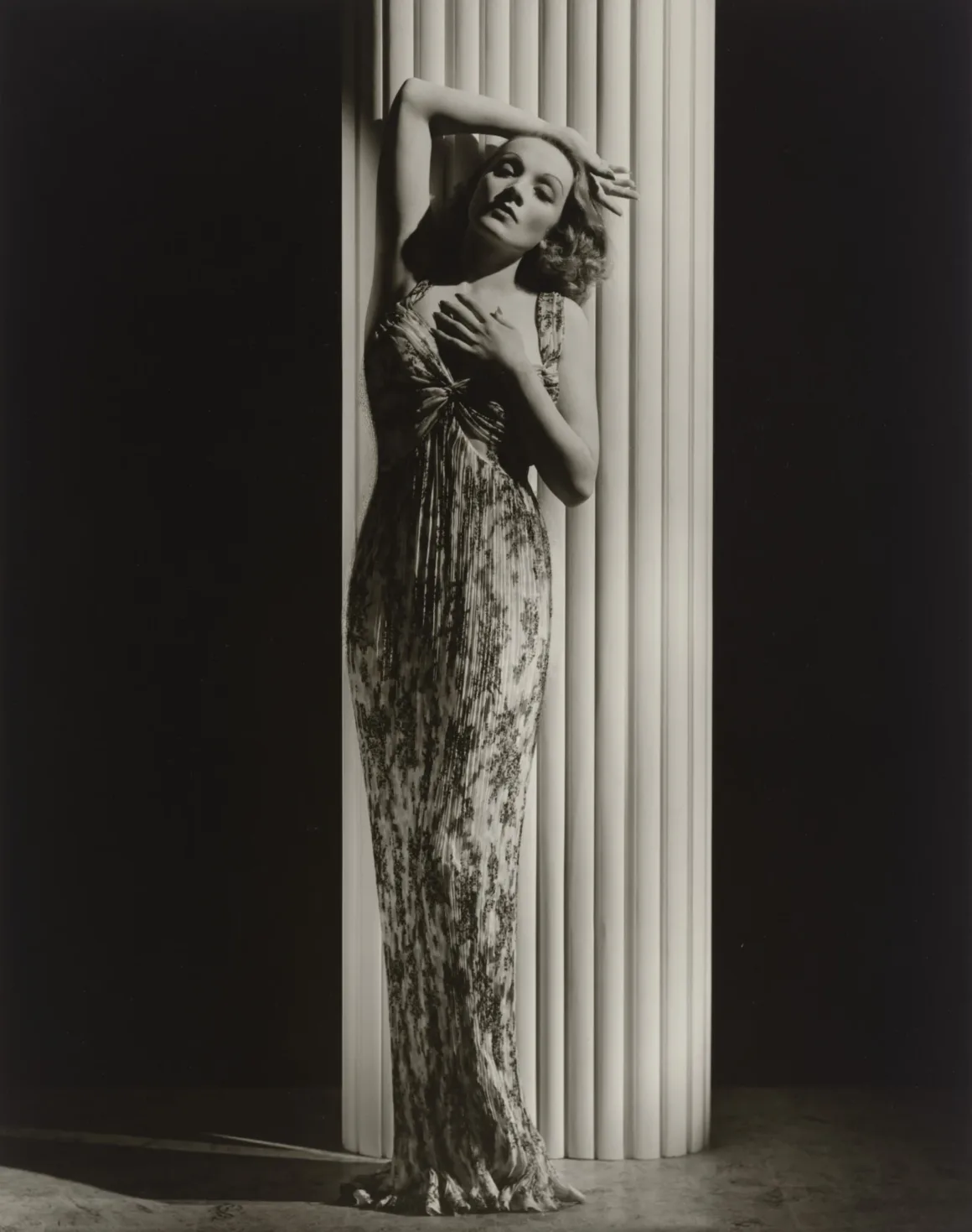 Hollywood’un Altın Çağındaki Glamoru Fotoğraflayan Adam: George Hurrell 18 Hollywood’un Altın Çağındaki Glamoru Fotoğraflayan Adam: George Hurrell
Dalgalı saçlı bir kadın, uzun desenli kolsuz elbisesiyle büyük ve yivli beyaz bir sütunun önünde poz veriyor.