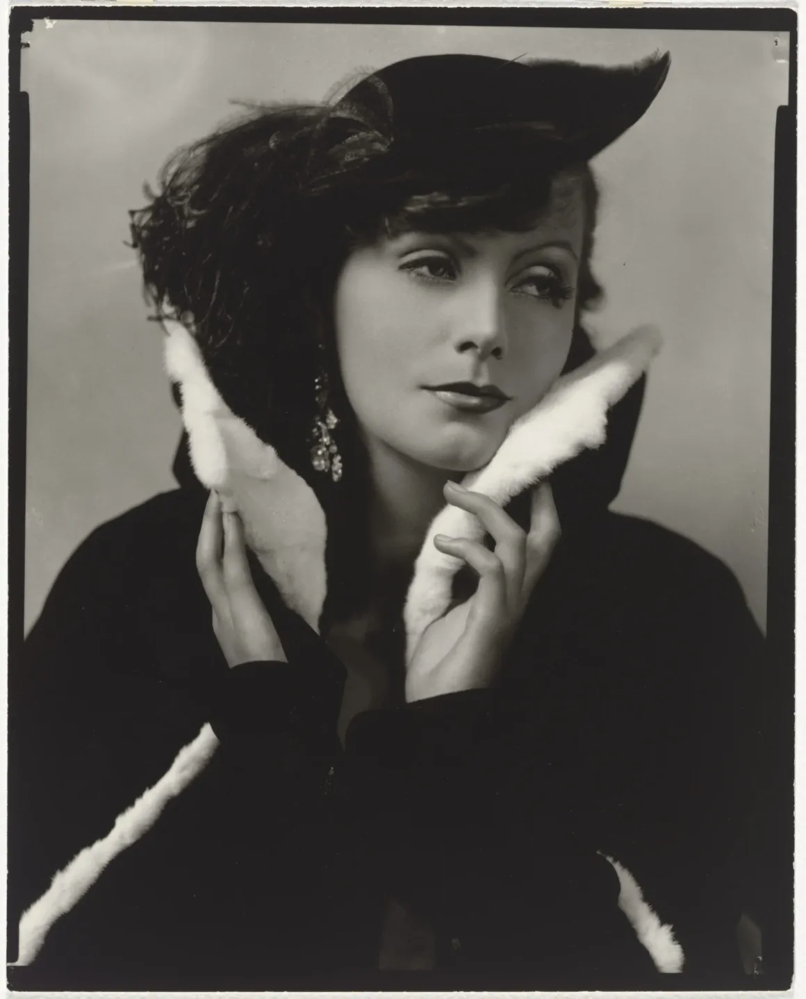 Hollywood’un Altın Çağındaki Glamoru Fotoğraflayan Adam: George Hurrell 27 Greta Garbo, beyaz kürk yakalı koyu renk palto ve tüylü şapka giyiyor; yakasını çenesine kadar kaldırmış.
